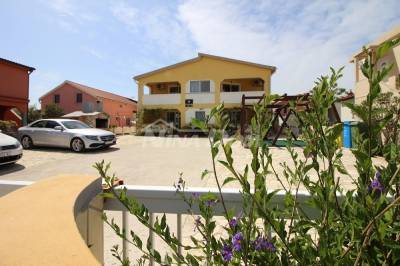 Apartmanska kuća s prostranom okućnicom.